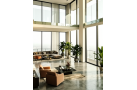 Vaste intérieur loft moderne avec canapé et fauteuils, grandes fenêtres, plantes d’intérieur et lumière naturelle. Garde-corps e